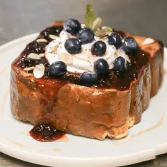 French Toast — Yogurt Greco con Acai, Confettura Ai Lamponi, Scaglie Di Mandorla Tostata, Mirtilli Freschi E Semi Di Chia